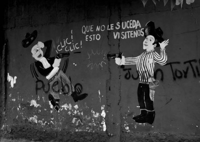 Graffiti representing the advertising of Guns Shop. Someone has written on "Pueblo" People and "Juan Tortilla" representing Juan Orlando Hernández, President of Honduras.